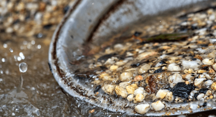 A collection of small rocks in a gold pan A collection of small rocks in a gold pan